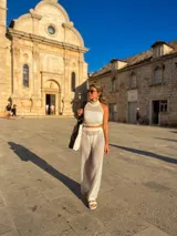 Top blanco tejido calado con cuello halter y corte crop.