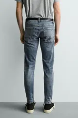 Jeans skinny fit de corte ajustado y tiro medio en color negro con efecto lavado y detalles desgastados. Confeccionados en tejido elástico con mezcla de algodón, presentan diseño clásico de cinco bolsillos y cierre frontal con cremallera y botón.