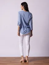 Blusa Ninety color beige con textura, cuello base con escote en V y abertura central con botones. Tiene un bolsillo en el pecho y mangas 3/4 regulables con presilla y botón.