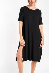 Vestido midi negro de manga corta, confeccionado en tejido de punto acanalado, con cuello redondo y corte recto.