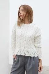 Sweater color crema tejido con diseño de trenzas y calados en el ruedo.