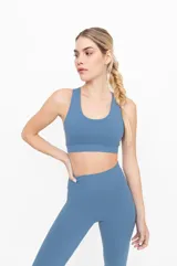 Top deportivo color celeste, con espalda cruzada y compresión alta.