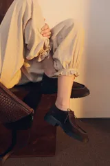 Zapato tipo wallabee de gamuza azul con costuras blancas a la vista y suela de goma negra con plataforma.