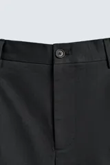 Bermuda corta de corte regular confeccionada en tejido de algodón, con pliegues frontales, bolsillos laterales y bolsillos traseros de doble vivo con botón.