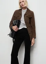 Jeans de terciopelo color negro, tiro alto y estilo flare, con diseño de cinco bolsillos y trabillas para cinturón.