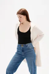 Saco largo de punto con capucha, diseño holgado y bolsillos frontales.