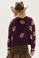 Sweater de punto color bordó con diseño de flores estampadas en tono crema, cuello redondo y puños con detalle de franjas en contraste. Presenta un bordado pequeño en el pecho.