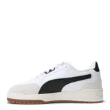 Championes Puma modelo Shuffle Downtown, de diseño retro urbano. Presentan una base blanca con detalles en negro, incluyendo la franja lateral característica de la marca, y refuerzos de gamuza en la puntera y el talón. Cuentan con suela de goma color caramelo y plantilla SoftFoam+ para mayor confort.