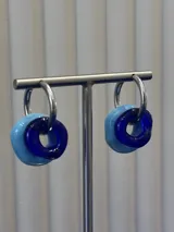 Aros tipo argolla de plata 925 con dijes circulares de vidrio en tonos azul y celeste.