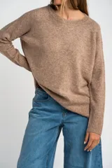 Sweater de tejido de punto color bordó, con cuello redondo, mangas largas y puños acanalados. Presenta un diseño de corte recto y textura suave.