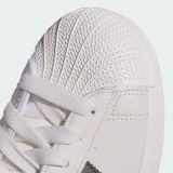 Championes Adidas Superstar de diseño clásico, color blanco con las icónicas tres tiras laterales en tono gris oscuro. Presenta detalle de estampado animal print en el talón y puntera de goma reforzada.