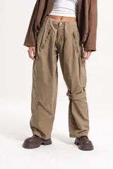 Pantalón cargo de tiro medio-alto en color verde oliva, con diseño holgado, múltiples cierres decorativos y funcionales, y bolsillos laterales.