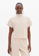 Blusa beige de manga corta con cuello alto.