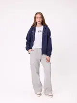 Canguro azul marino con cierre frontal, capucha y bolsillos laterales. Presenta un parche bordado con el número 85 en color celeste y blanco en la manga.