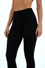 Calza larga negra de compresión media, con cintura alta de doble tela y corte en la parte posterior.