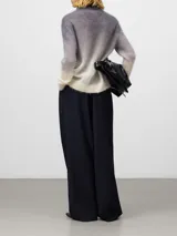 Jersey de punto cardado con diseño degradado, cuello chimenea y manga larga con hombro caído. Presenta remates en canalé en puños y bajo.
