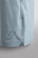 Pantalones deportivos cortos de tejido técnico ligero y elástico, con cintura elástica ajustable, bolsillos frontales y aberturas laterales en el bajo.