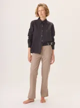 Camisa de manga larga con diseño combinado. Presenta mangas y parte superior delantera y trasera en color negro liso, mientras que el panel central de la espalda destaca por un estampado animal print de leopardo. Cuenta con cuello clásico, cierre frontal de botones y puños abotonados.