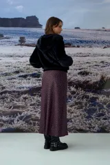 Chaqueta tipo teddy color negro, con capucha, cierre frontal metálico y puños tejidos.