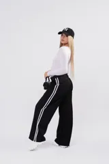 Pantalon de vestir negro de corte recto y tiro bajo, con franjas laterales blancas y cierre frontal.