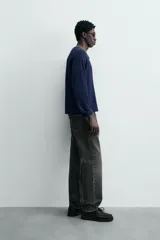 Camiseta de manga larga con cuello redondo y cierre frontal de botonadura tipo henley, confeccionada en tejido de punto con textura waffle.