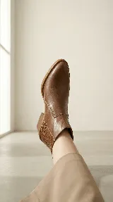 Bota corta tipo chelsea de cuero negro, con panel lateral texturizado y taco cuadrado bajo.