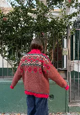 Buzo de punto grueso con cuello alto y diseño jacquard que presenta motivos de granjeros, casas y árboles en tonos crema, marrón, rojo y amarillo.