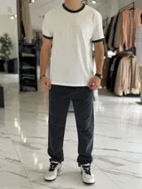 Remera oversize de algodón pesado en color blanco, con cuello redondo y ribetes en las mangas de color verde oscuro.