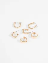 Set de tres pares de aros dorados con diferentes diseños: un par de argollas clásicas, un par de aros con forma orgánica irregular y un par de aros con forma orgánica irregular y pequeños cristales incrustados.