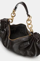 Bolso de hombro en color marrón oscuro con efecto craquelado. Presenta detalles fruncidos en los laterales con tiradores ajustables y un asa corta que combina una parte de material sintético con eslabones de cadena metálica dorada. Cuenta con un bolsillo interior y cierre mediante cremallera.