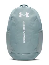 Mochila Under Armour modelo Hustle Lite, color verde grisáceo, con tecnología UA Storm resistente al agua. Cuenta con compartimento acolchado para portátil, dos bolsillos laterales de malla para botellas y panel inferior reforzado.