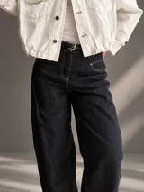 Jeans barrel de tiro alto, confeccionados en denim azul muy oscuro casi negro, con pespuntes contrastantes, diseño de pierna amplia y redondeada, y bolsillos delanteros.