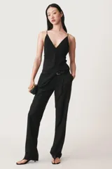 Top negro de seda con escote en pico, tirantes finos ajustables con lazadas, bajo recto con aberturas laterales y cierre en la espalda con cremallera oculta.