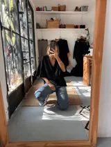 Blusa de crepé color negro, con escote en V y mangas tres cuartos con terminación de volados.