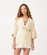 Kimono color crema de tejido viscolino con mangas anchas y lazo en la cintura.