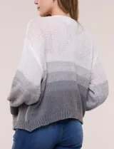 Cárdigan de punto abierto y calado con silueta holgada y hombros caídos, diseño degradado en tonos blanco, rosado y rojo. Presenta frente abierto sin botones y mangas largas abullonadas con terminación en puño acanalado.