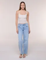 Jean wide leg de tiro medio, marca DJEANS, en tono azul claro con efecto acid wash. Presenta pretina con pasadores, cierre y botón, bolsillos delanteros inclinados y bolsillos traseros aplicados.