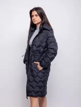 Campera larga color marrón con diseño acolchado, capucha desmontable, cierre frontal con botones a presión, bolsillos laterales con cierre, puños elásticos y cintura ajustable.