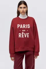 Buzo de cuello redondo con hombros caídos y diseño estampado con texto en el frente. Presenta puños y bajo acanalados.