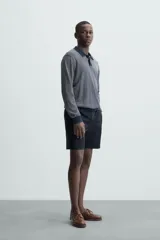 Bermuda de hombre color beige claro, corte regular fit, con pliegues frontales, bolsillos delanteros y bolsillos traseros de doble vivo con botón.