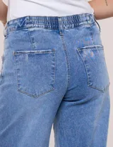 Jean de tiro alto y pierna ancha de denim azul oscuro, con cinco bolsillos y pretina trasera elastizada.