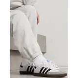 Championes Adidas Samba OG blancos con tres tiras negras a los costados y suela marrón de goma.