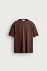Camiseta relaxed fit confeccionada en tejido de algodón con textura irregular. Cuenta con cuello redondo y manga corta.