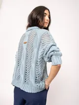 Sweater tejido de algodón color crudo, con cuello polo y escote en V. Diseño con ochos verticales en delantera, espalda y mangas, y punto abierto.