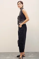 Pantalón jean negro de corte ancho y largo midi, con diseño de perneras holgadas y costuras frontales marcadas.