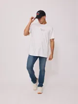 Gorra trucker Rusty con visera gris, frente blanco con logo estampado y malla trasera gris.