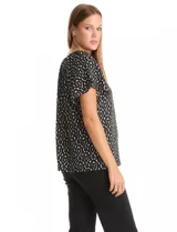 Blusa de crepe con estampado geométrico en blanco y negro, cuello redondo elastizado con frunces y mangas cortas amplias.