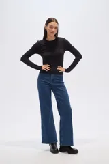 Remera verde esmeralda de manga larga, corte ajustado y cuello redondo.