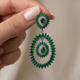 Caravanas colgantes de plata 925 con diseño floral y ovalado, adornadas con piedras verdes en forma de marquise y gota, rodeadas de pequeños cristales brillantes.