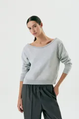 Sweater gris claro de lana con escote en V profundo.